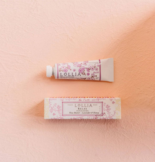 Mini white tube and box of Lollia Relax Handcreme both feature delicate pink floral patterning