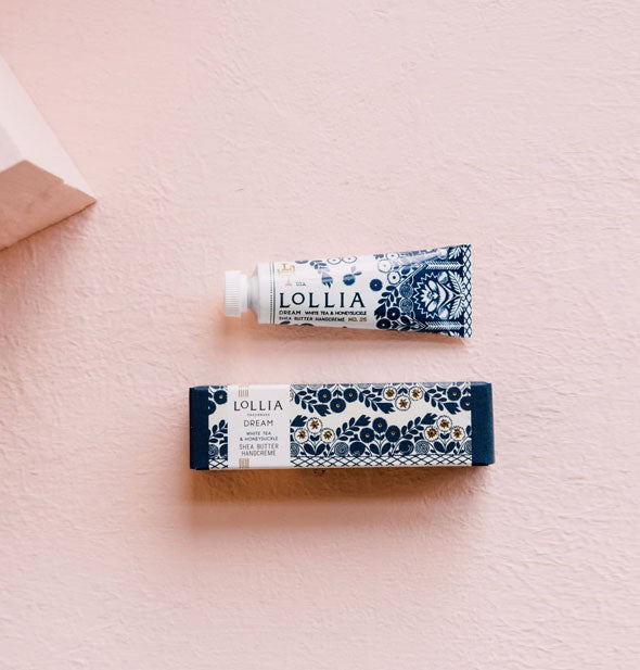 Mini white tube and box of Lollia Dream Handcreme patterned with dark blue florals accented by gold
