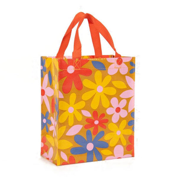 Brown tote bag with reddish-orange top handles features an all-over floral design in red, pink, yellow, and blue