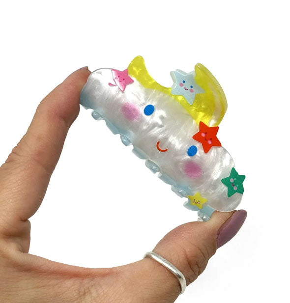 Model's hand holds the Happy Cloud claw clip between thumb and index finger for size reference