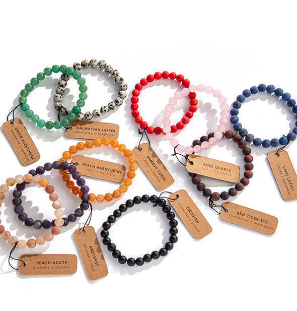 An arrangement of beaded bracelets in varying colors and stone types with corresponding labels.