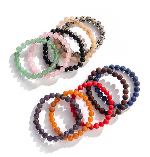 An arrangement of beaded bracelets in varying colors and stone types.