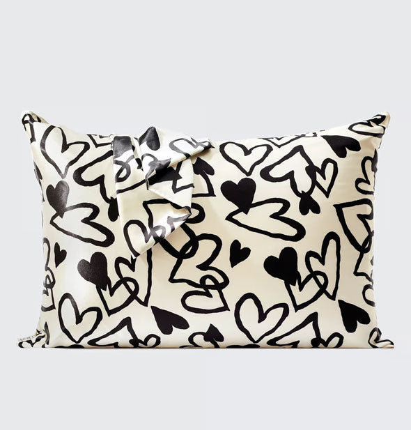 White pillowcase with all-over black hearts, some outlined and some filled in, in a hand-drawn style