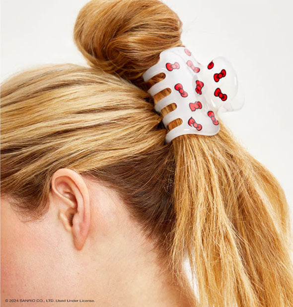 Model wears a white and red mini bows claw clip in a twisted-up hairstyle