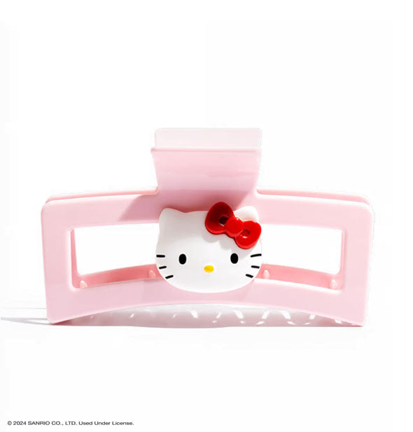 Light pink open shape rectangular claw clip with white Hello Kitty Face at the center, complete with her iconic red bow, yellow nose, and black eyes and whiskers