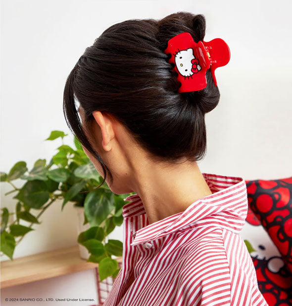 Model wears a red Hello Kitty face claw clip in a twisted-up hairstyle