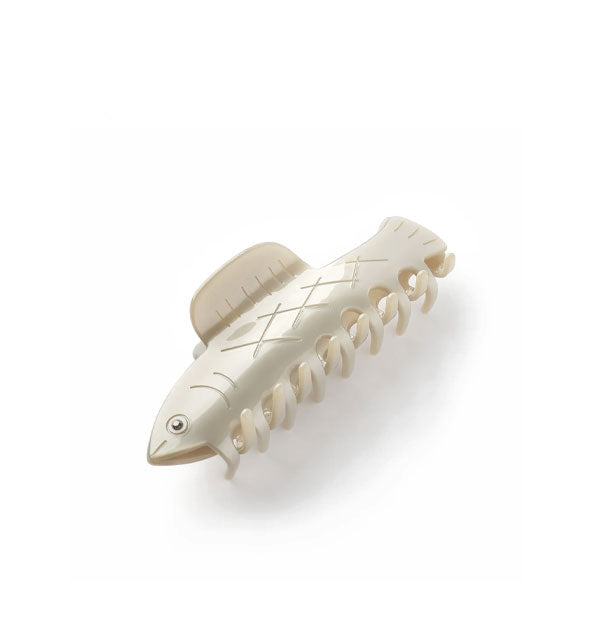 Whitish fish claw clip with etched details and a rhinestone eye