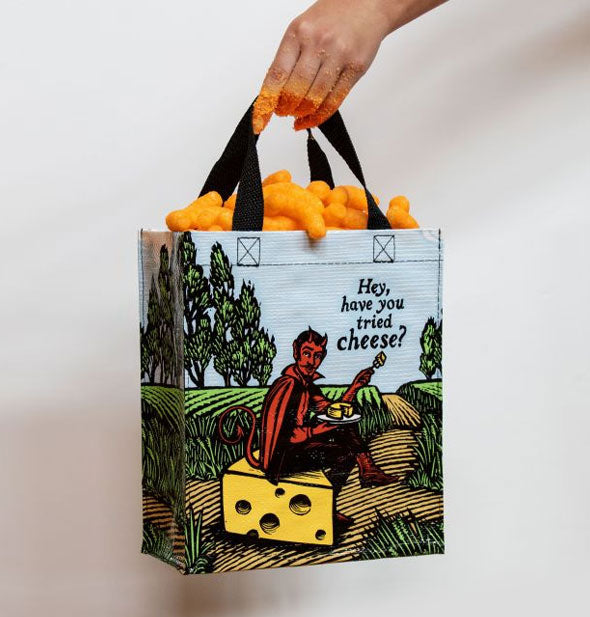 Model's cheese puff powder-covered hand holds a Hey, Have You Tried Cheese? Tote (which is filled with cheese puffs) by the handles