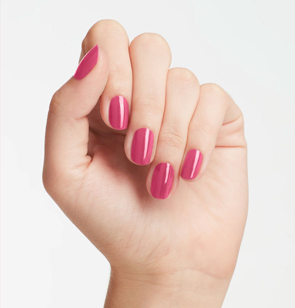 Model's hand wears a medium-to-dark shade of pink nail polish
