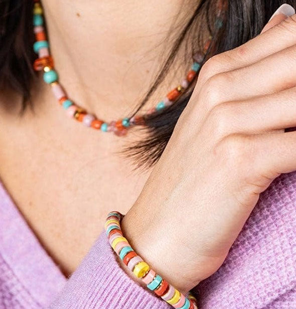 Model poses wearing the multicolor bead Hillary bracelet with a purple sweater