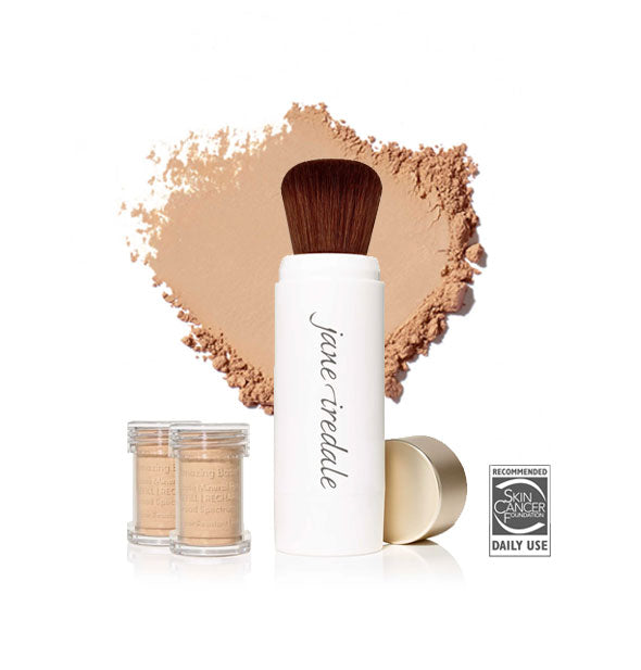 White Jane Iredale powder brush with gold cap removed and set to the side, two refill canisters nearby, and an enlarged product sample in the background in shade Honey Bronze