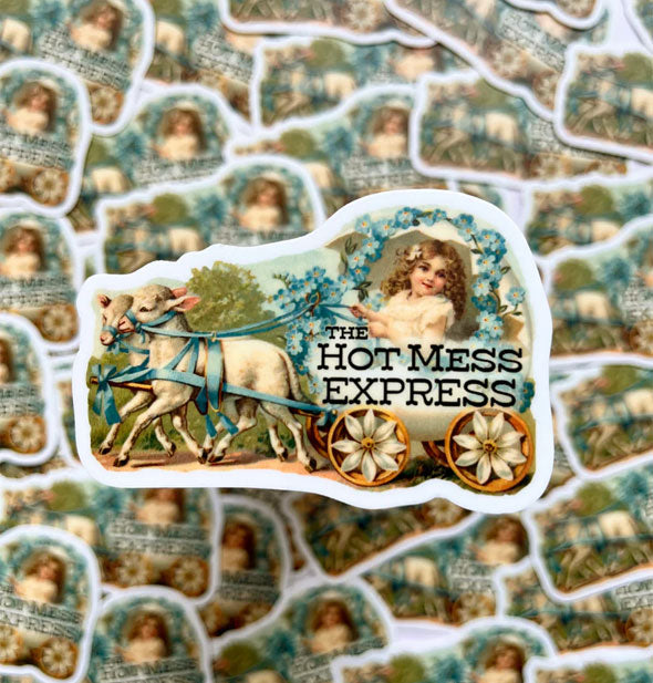 Sticker featuring an antique-style illustration of a little girl riding in a lamb-drawn carriage accented with flowers says, "The Hot Mess Express" in black lettering overtop