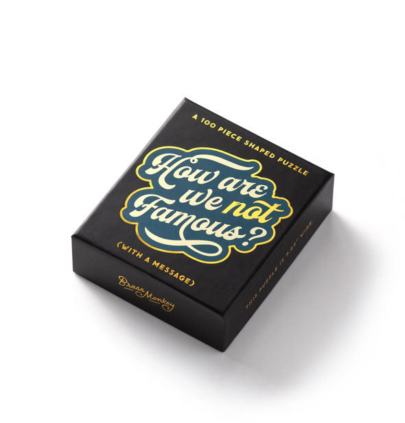 Black 100-piece "How Are We Not Famous?" puzzle box with gold, blue, and white design accents