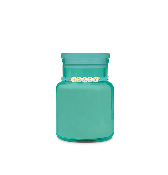 Blue-green glass jar candle with beaded "Howdy" bracelet around its neck
