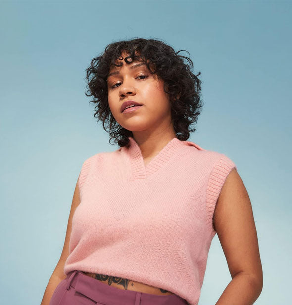 Model with soft, smooth, defined curls poses against a blue backdrop