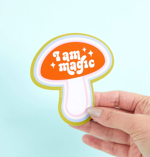Model's hand holds an I Am Magic mushroom sticker
