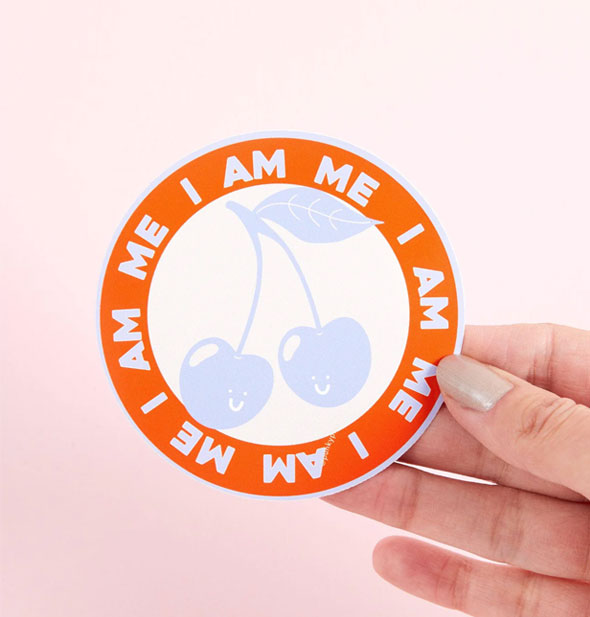 Model's hand holds the I Am Me Cherries sticker for size reference
