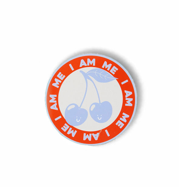 Round sticker says, "I Am Me" in repeating blue lettering in an outer red ring that encircles a pair of smiling blue cherries