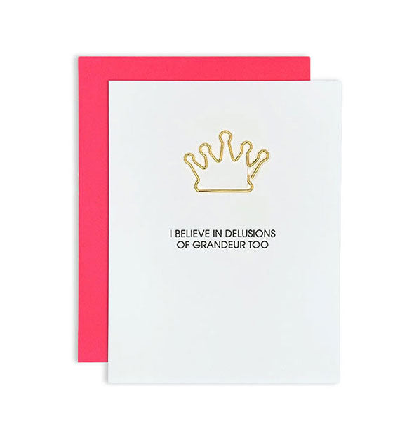 White greeting card with hot coral envelope behind and gold crown attached says, "I believe in delusions of grandeur too" in black lettering