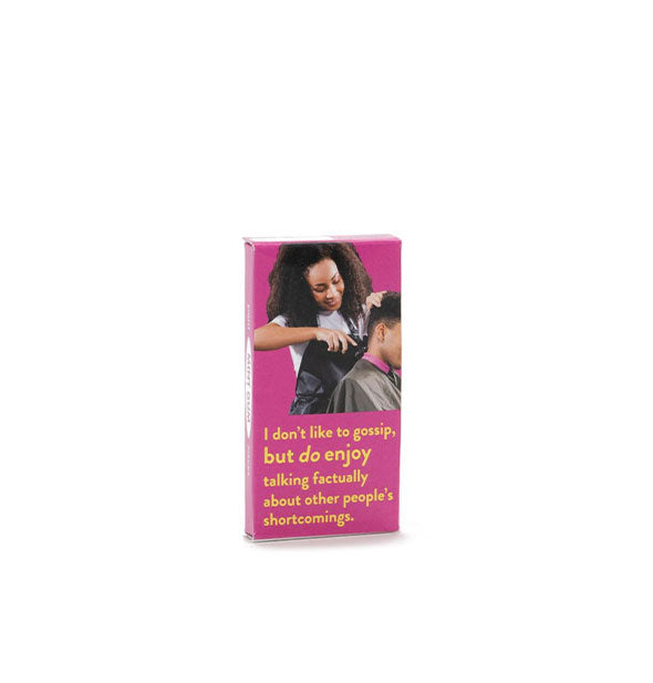 Flat rectangular pink box with image of a woman cutting a man's hair says, "I don't like to gossip, but I do enjoy talking factually about other people's shortcomings" in yellow lettering