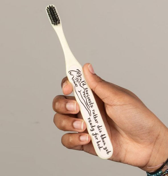 A model's hand holds the "I'd seriously rather die than get ready for bed" toothbrush