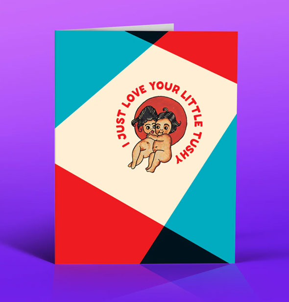 Greeting card with black, teal, and red color blocking features two naked cherub-like cartoon figures near the center inside the caption, "I just love your little tushy" printed in red lettering