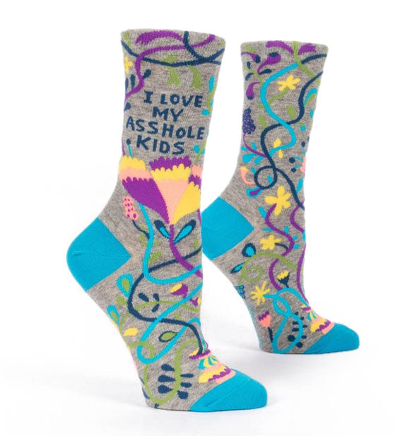 Pair of gray crew socks with blue heels and toes feature all-over colorful floral and vine designs and the words, "I love my asshole kids" printed on the ankles