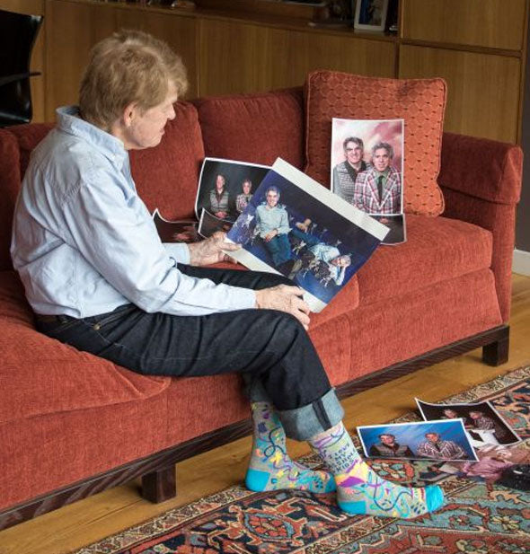 Model gazing at family portraits wears a pair of I Love My Asshole Kids crew socks