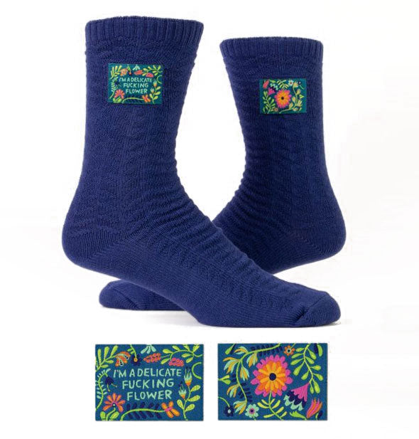 Pair of dark blue socks, one of which features a label that reads, "I'm a Delicate Fucking Flower"