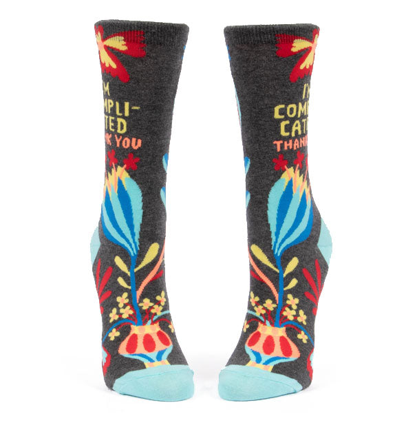 Dark grey crew socks with colorful floral design and "I'm complicated thank you" printed on the outer ankle