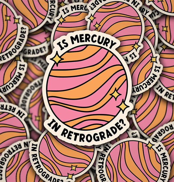 Pile of stickers illustrated to resemble a planet flanked by yellow stars say, "Is Mercury in retrograde?" divided between top and bottom in black lettering