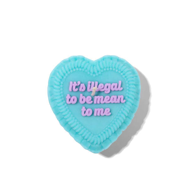 Top view of a blue heart-shaped candle designed to look like a cake iced with the message, "It's illegal to be mean to me" in purple lettering