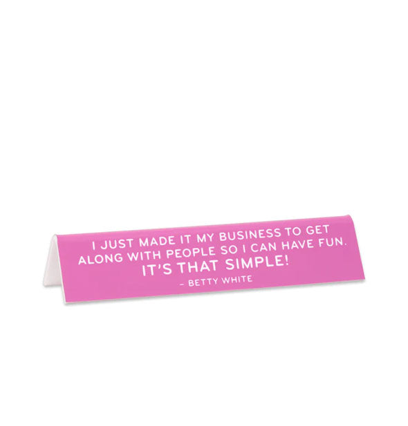 Rectangular pink sign says, "I just made it my business to get along with people so I can have fun. It's that simple!" - Betty White" in white lettering