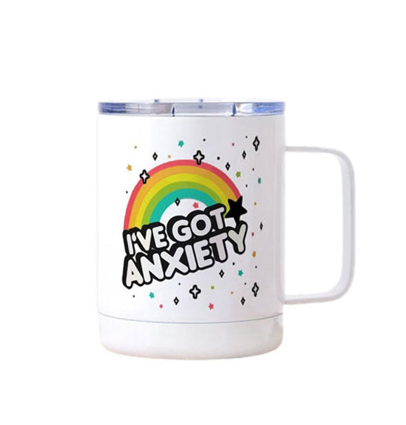 White travel mug with clear lid and squared handle says, "I've got anxiety" in bubble lettering with a black shadow effect underneath a rainbow and surrounded by stars