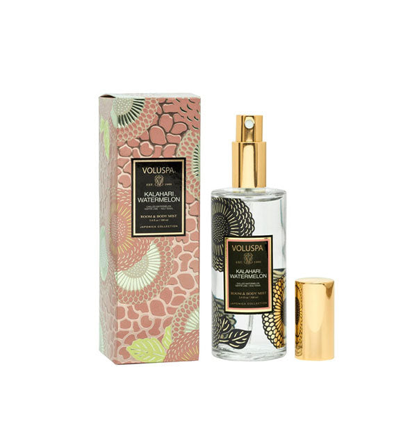 Floral-patterned clear glass bottle of Voluspa Kalahari Watermelon Room & Body Mist next to pink pebbled gift box with silver and gold floral pattern