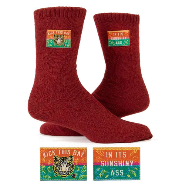 Pair of brick red socks with sewn-in tags featuring tiger head illustration and the words, "Kick this day in its sunshiny ass"