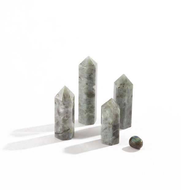 Grouping of five greenish-gray labradorite stones, four of which are tall with points and feature a flecked patterning