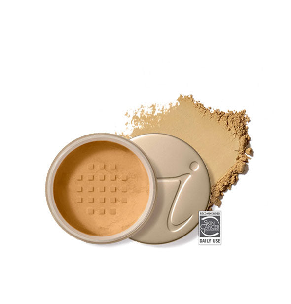 Opened round Jane Iredale loose powder compact with stamped gold lid and product application behind it in shade Latte