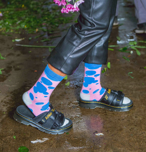 Model wears Lava Lamp crew socks on wet pavement with black slides and black leather cropped pants