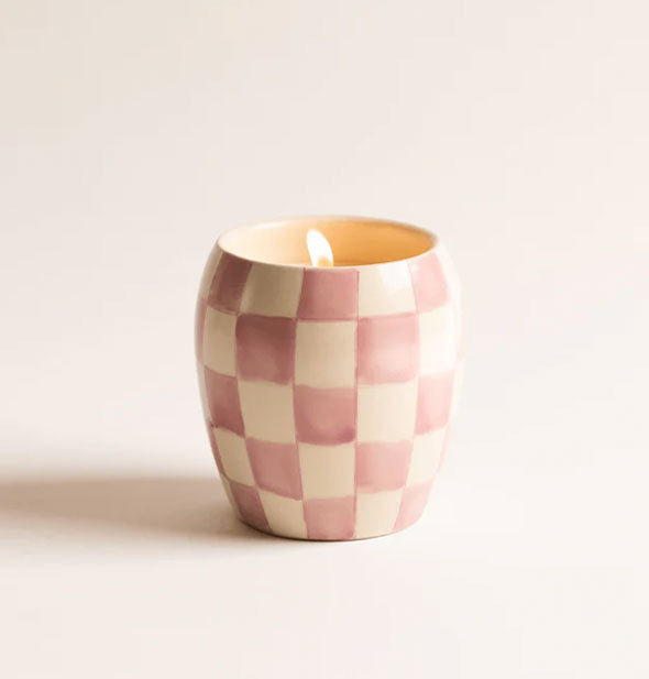 Lid candle in a purple and white checkered ceramic vessel
