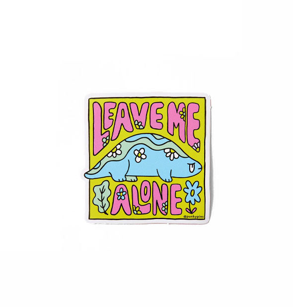 Square sticker features illustration of a blue reptile accented with plants and flowers and says, "Leave Me Alone" in pink lettering