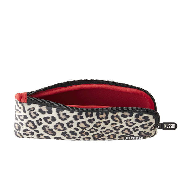 Unzipped leopard print KUSSHI pouch reveals its red interior lining