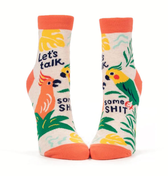Pair of colorful, tropical-themed socks each feature designs of cockatoos and the words, "Let's talk some shit" in black lettering