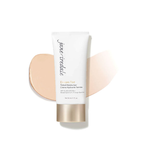 White and gold tube of Jane Iredale Dream Tint Tinted Moisturizer with enlarged smeared product application behind in shade Light