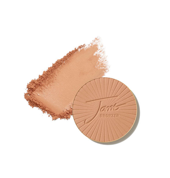 Round stamped Jane Bronzer compact refill with crushed product sample swatch behind, both in Light shade