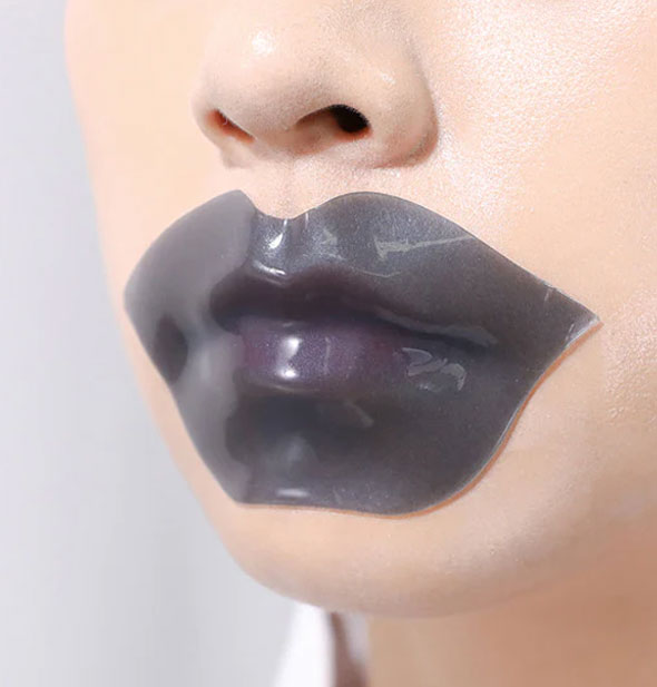 Model wears a black lip-shaped mask over mouth