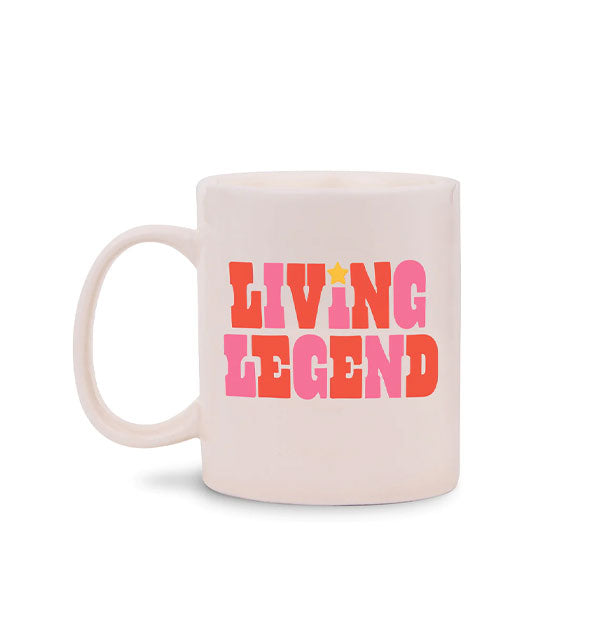 White coffee mug says, "Living Legend" in alternating pink and red-orange lettering with a gold star dotting the I