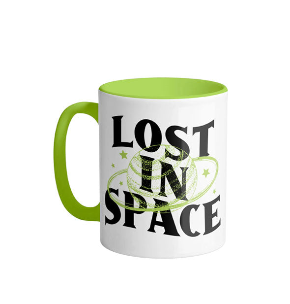 White coffee mug with green handle and interior says, "Lost in space" in large black lettering partially overlaid by green planet design