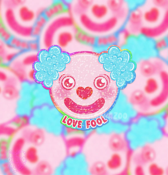 Sticker designed as a pink clown's face with a heart-shaped nose and puffy blue hair says, "Love fool" and rests on a blurred backdrop of others like it