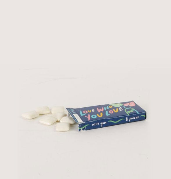 Slim box on its side spills out pieces of white chewing gum